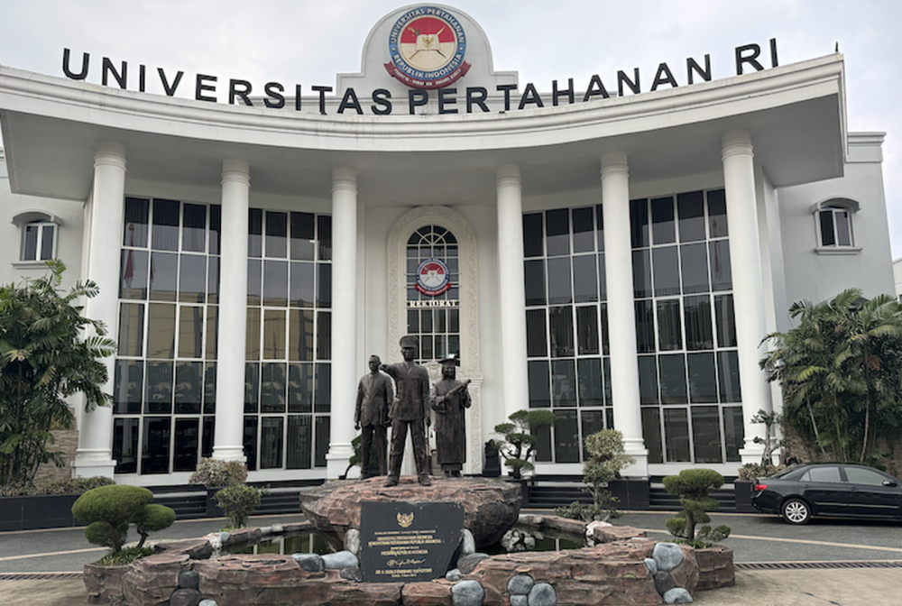 Gedung Universitas Pertahanan Republik Indonesia dengan logo Unhan RI dan patung di bagian depan gedung.