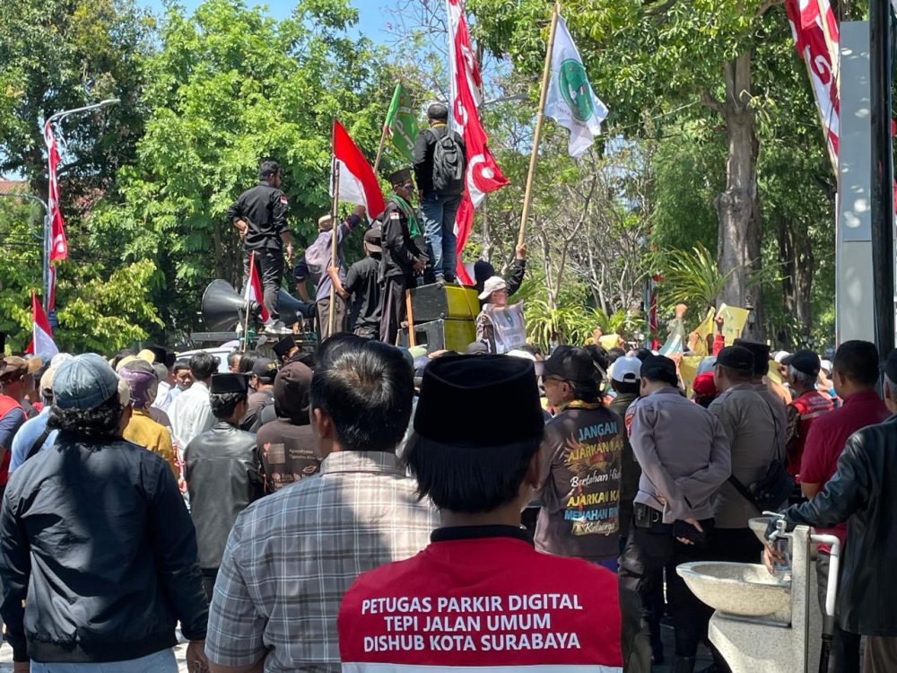Ratusan jukir Surabaya menggelar aksi menolak penerapan parkir digital QRIS di depan Balai Kota Surabaya