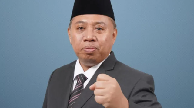 Rektor Universitas Jenderal Soedirman (Unsoed) Akhmad Sodiq mengenakan jas dan peci hitam dalam foto resmi.