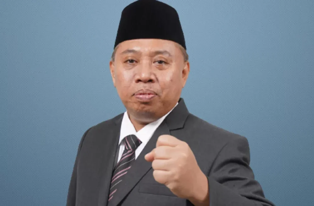 Rektor Unsoed Akhmad Sodiq Rektor Universitas Jenderal Soedirman (Unsoed) Akhmad Sodiq mengenakan jas dan peci hitam dalam foto resmi.