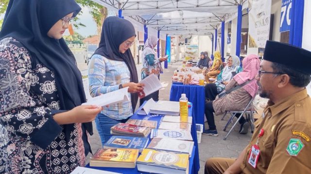 Pengunjung melihat koleksi buku di stan pameran Festival Literasi Lumajang 2026 yang digelar di halaman Perpustakaan Mula Malurung.