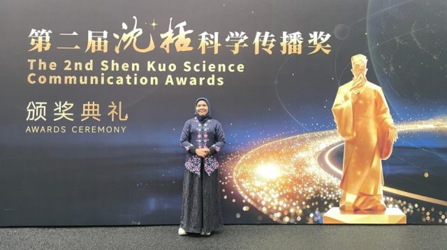 Daru Setyorini berdiri di depan latar The 2nd Shen Kuo Science Communication Awards di China.