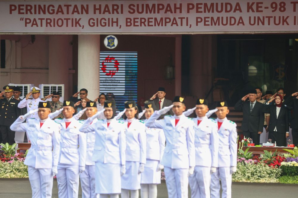 Pasukan pengibar bendera memberi hormat saat upacara Hari Sumpah Pemuda ke-98 di Balai Kota Surabaya, Rabu (28/10/2026).
