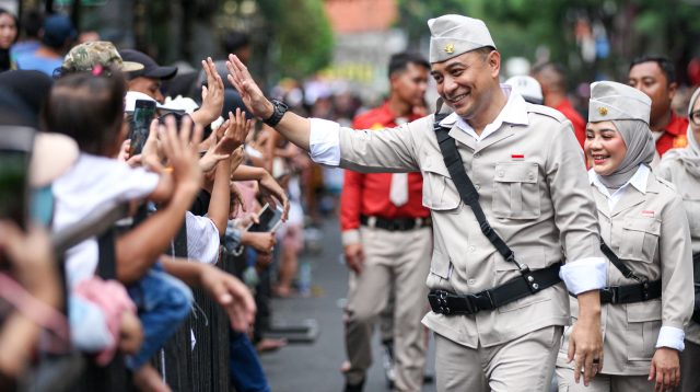 Wali Kota Surabaya Eri Cahyadi menyapa warga dengan melakukan tos saat mengikuti Parade Surabaya Juang 2025.