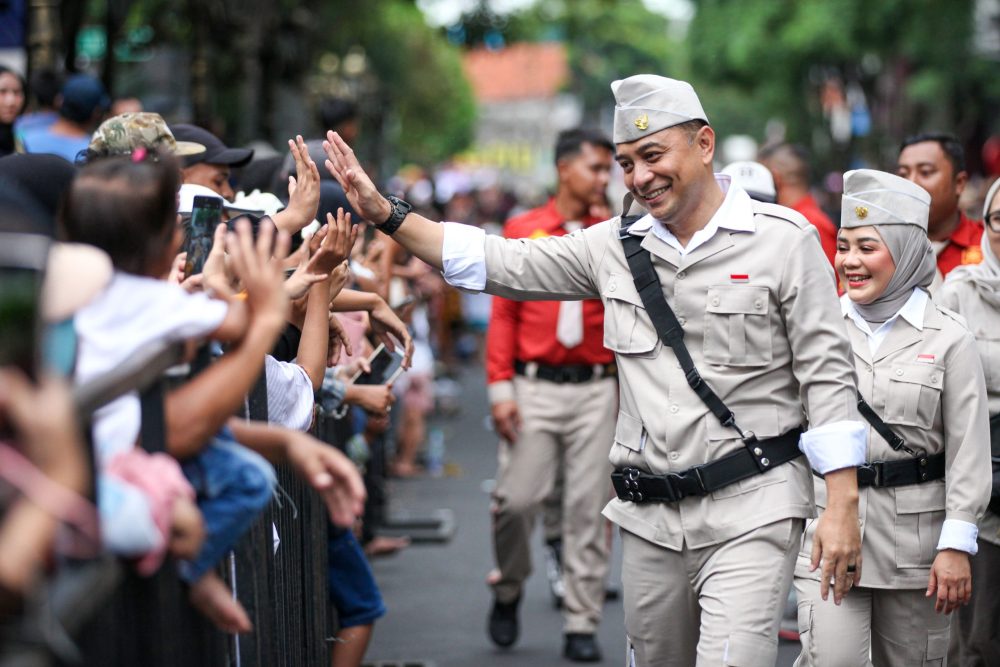 Wali Kota Surabaya Eri Cahyadi menyapa warga dengan melakukan tos saat mengikuti Parade Surabaya Juang 2025.