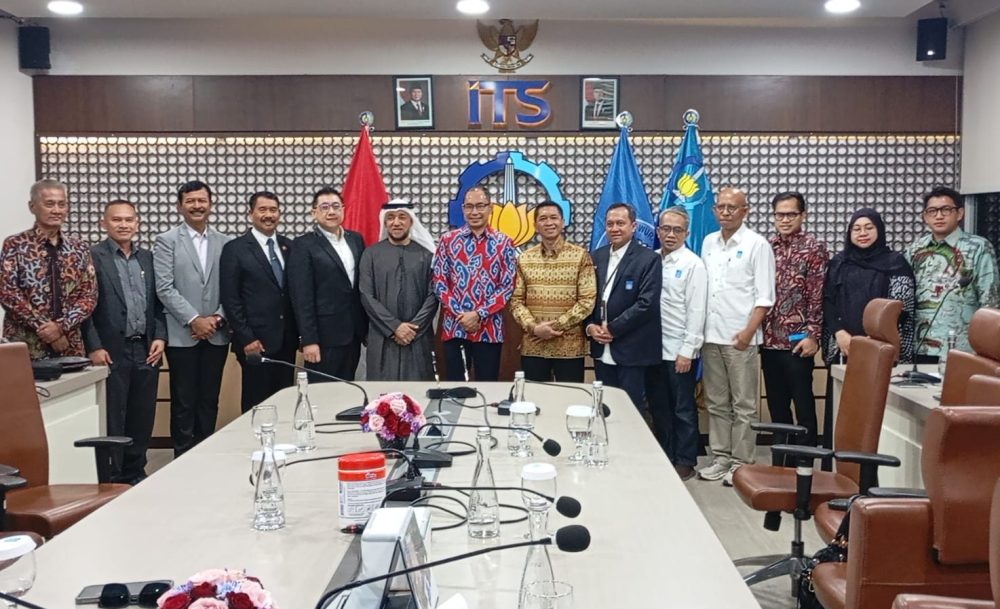 Jajaran perwakilan BTI Defence, ITS, dan Iridium berfoto bersama di depan logo ITS dalam kerja sama pengembangan teknologi kelautan dan industri pertahanan.