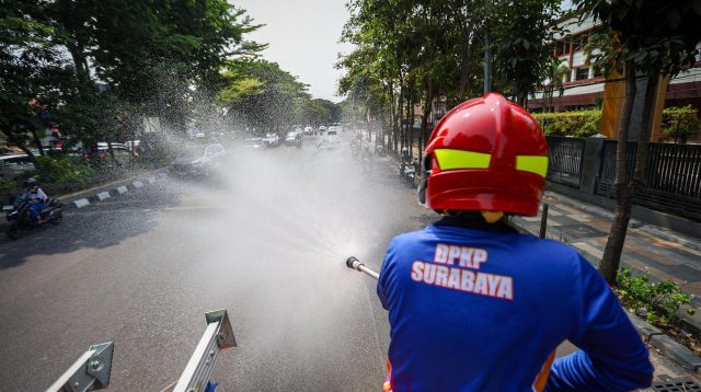 Cuaca Panas, Damkar Surabaya Lakukan Pembasahan Ruas Jalan