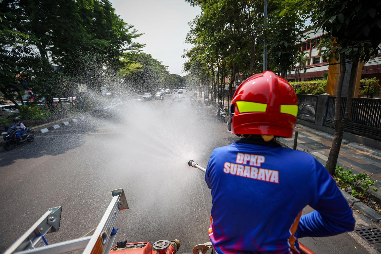 Cuaca Panas, Damkar Surabaya Lakukan Pembasahan Ruas Jalan