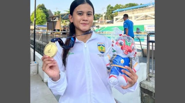 Syabilla Rizkia Putri Raharja, atlet selam asal Jepara, memegang medali emas dan boneka hadiah usai meraih prestasi di Porprov XVII Jawa Tengah 2026.